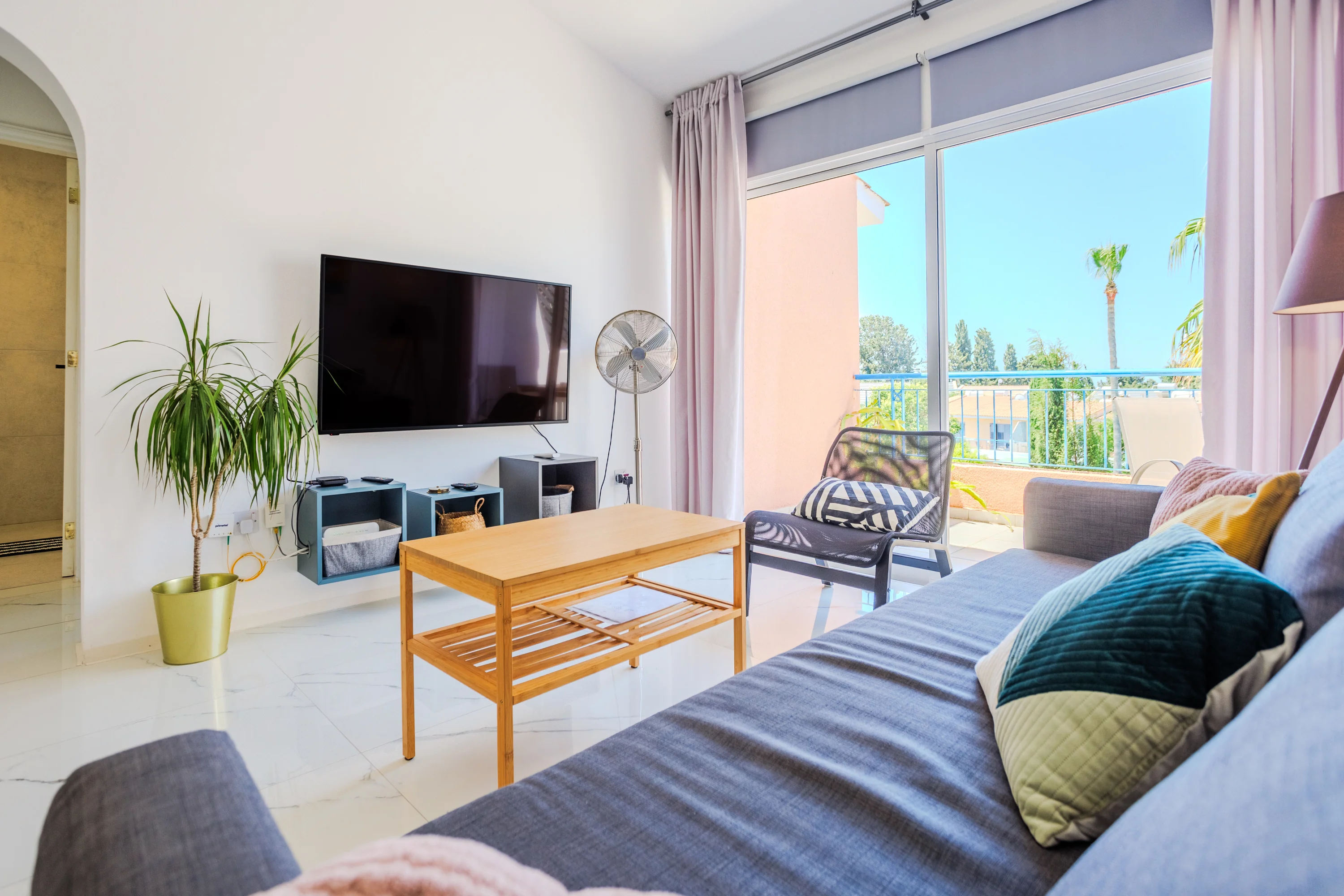 Living room with wall-mounted TV and balcony view