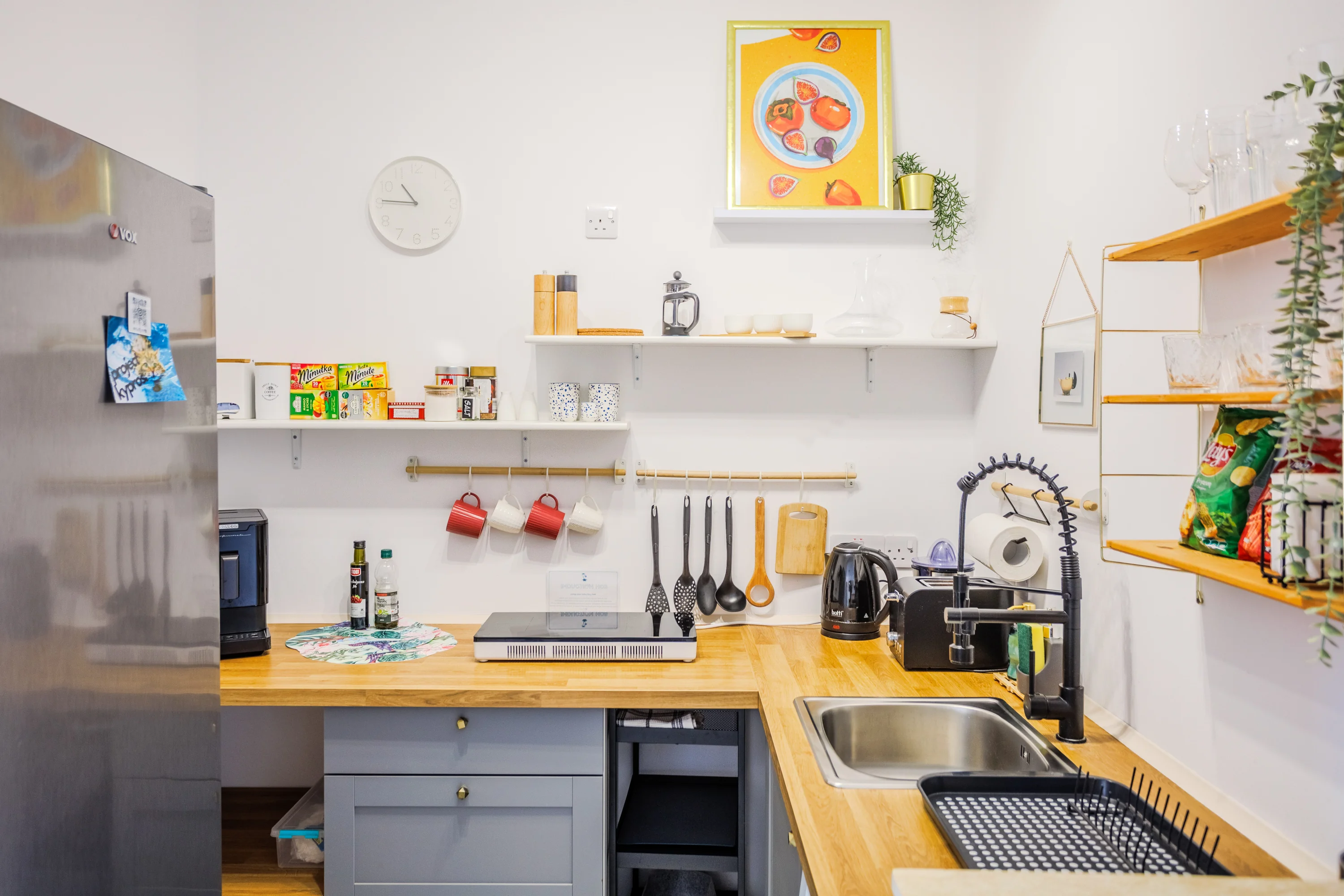 Kitchen with induction hob, coffee machine and open shelving