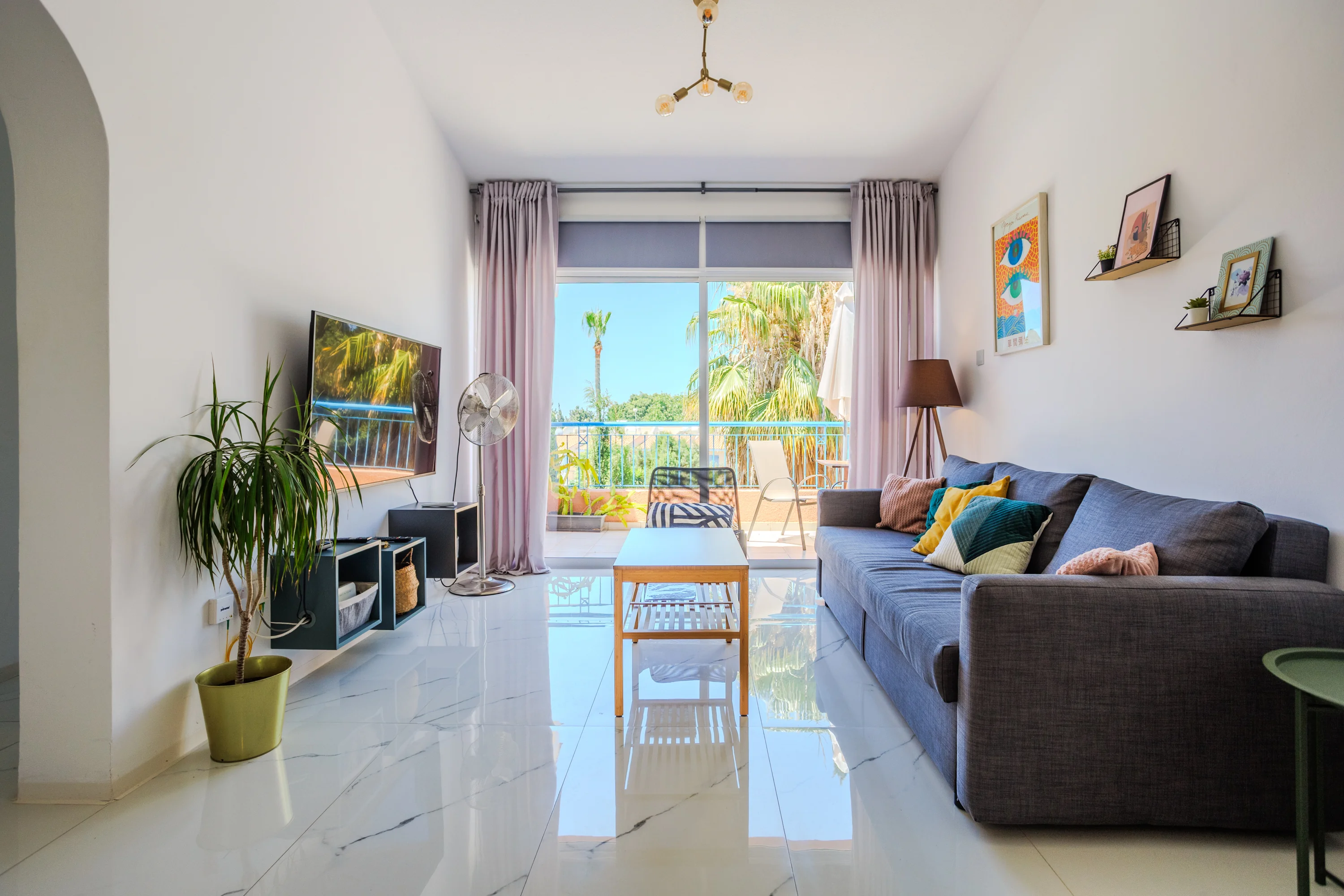 Living room with sofa bed and balcony doors at Paradise Gardens 3