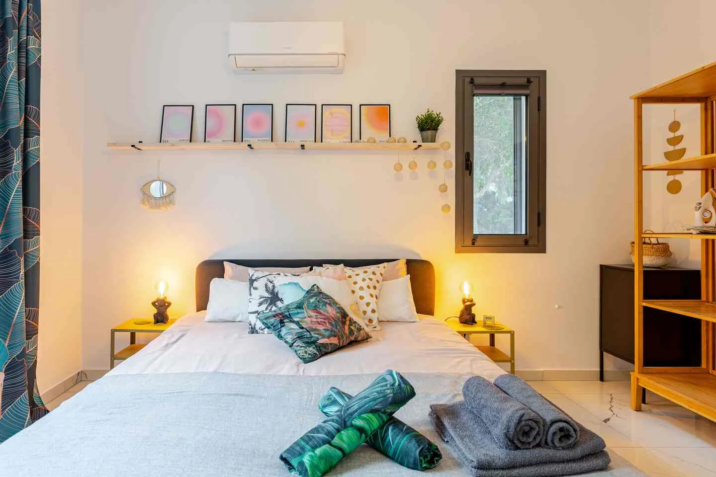 Double bed with bedside lamps and print shelf