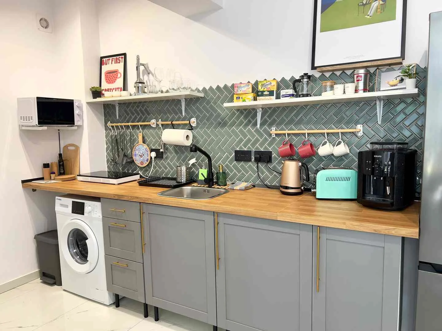 Kitchen with washing machine, hob and open shelving